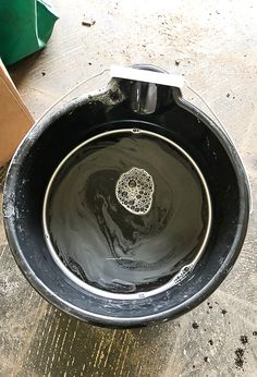 a black bowl sitting on top of a wooden table