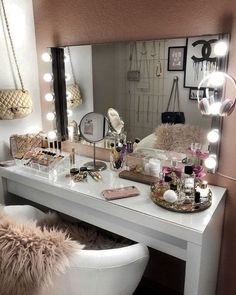 a white vanity with lights on it and a chair in front of the mirror next to it