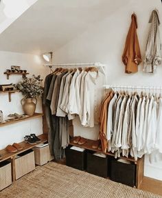 an organized closet with clothes and shoes hanging on the wall, along with storage bins