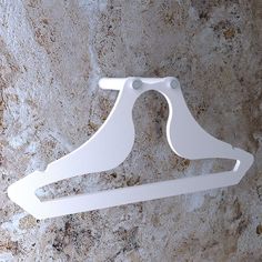 a pair of white clothes hangers on a marble wall