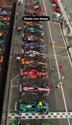 many cars are parked in a parking lot with people looking at them from the window