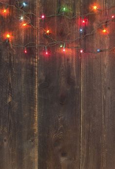 a wooden fence with christmas lights on it