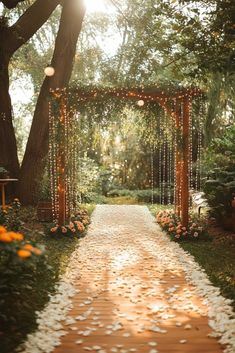 an outdoor wedding ceremony with white petals on the ground and lights strung from the trees