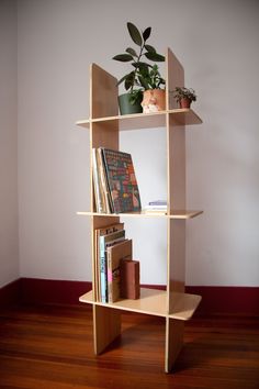 a wooden shelf with books and plants on it