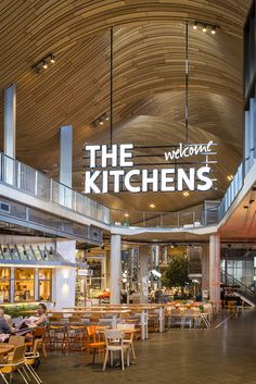 the inside of a restaurant with tables and chairs under a sign that reads the kitchen