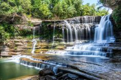 a large waterfall in the middle of a forest