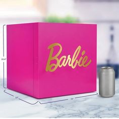 a pink box sitting on top of a counter next to a can