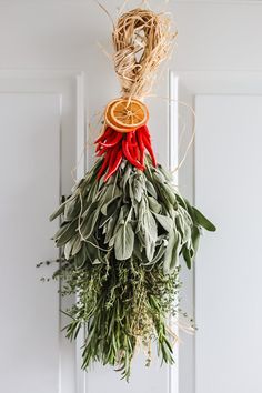 a bunch of dried herbs hanging from a door with orange slices and leaves on it