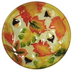 a yellow plate with orange and green leaves on it