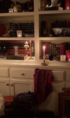 the bookshelves are filled with many different types of books and candles on them