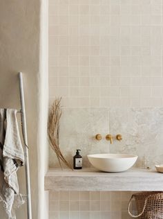 a white sink sitting on top of a counter next to a towel rack and mirror