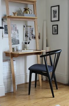 a chair sitting in front of a desk with a book shelf on top of it