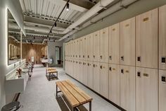 lockers are lined up along the wall in an office setting with benches and tables