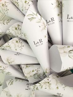 a bunch of white paper cones with floral designs on them and the words l & r printed on them