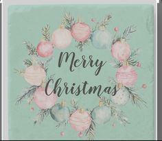 a merry christmas card with ornaments and pine branches in the center on a mint green background