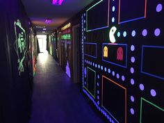 the hallway is decorated with neon lights and pac - man wallpapers on the walls