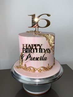 a pink and gold birthday cake with the number six on it