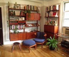 a living room filled with furniture and bookshelves on top of wooden flooring