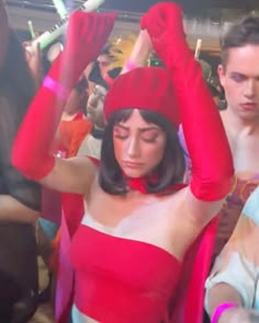 a woman in a red and white dress dancing with other people