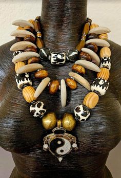 This bold, chunky and lightweight triple strand statement necklace or chest piece is gorgeous on either women or men. Three strands of brass, zebu bone, wood, moroccan resin, Nepalese glass, hematite, tiger's eye, rhinestone rondelle and frosted glass make up the components.  This adjusts from 17-20" with silvertone hardware, a lobster claw clasp and a 2" extender chain. From the Atelier of Kat Kouture! Rocker Chic Accessories, African Inspired Jewelry, Braided Bracelet Diy, Unique Pendant Necklace, Necklace Mens, Statement Bib Necklace, Chest Piece, Beaded Bracelet Patterns, Mermaid Necklace