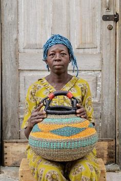 a woman sitting in front of a door holding a basket