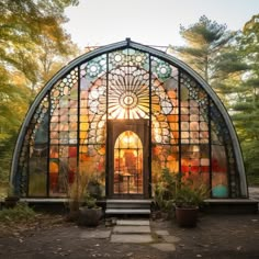 a colorful stained glass building with potted plants in the foreground and trees in the background