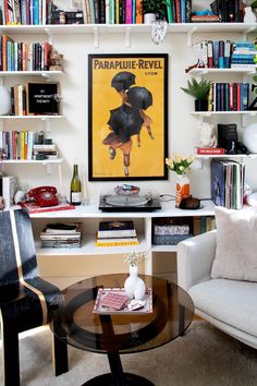 a living room filled with lots of books and furniture