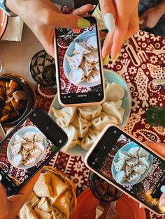 three people are taking pictures of food on their cell phones