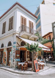 an outdoor cafe with tables and chairs on the street