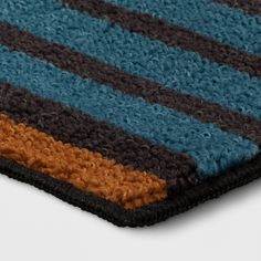 a blue, brown and black striped rug on a white surface with no people around it