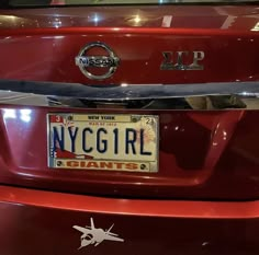 a red car with a license plate that says new york girl giants on the front