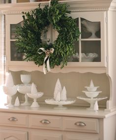 a wreath on top of a china cabinet