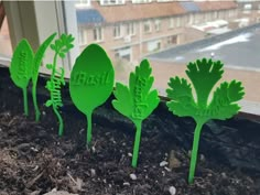 four green plastic plants sitting on top of a window sill