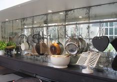 pots and pans are hanging on the wall behind a counter in a restaurant or bar