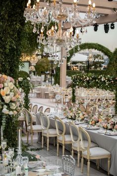 an outdoor dining area with chandelier and tables set for formal function or wedding reception