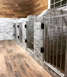 an empty jail cell with bars on the doors and wooden floors in front of it