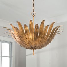 a gold chandelier hanging from a ceiling in a room with white walls and windows