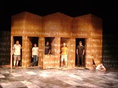 five people standing on top of a wooden structure with words written all over the walls