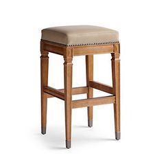 the backless stool is made from wood and has a beige upholstered seat