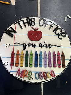 a cake with crayons and an apple on it