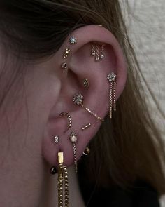 a close up of a person's ear with different types of piercings on it