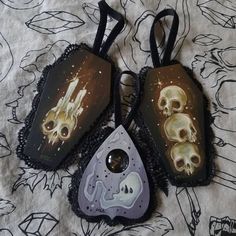 three pieces of cloth with skulls and bones on them sitting on top of a bed