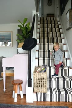 a young boy is standing on the stairs