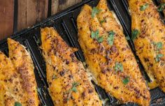 grilled fish fillets on a grill with parsley sprinkled on top