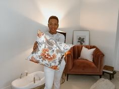 a woman holding up a pillow in her living room