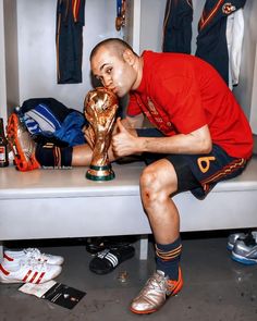 a man sitting on a bench holding a trophy