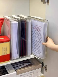 a person is reaching for files in a file cabinet