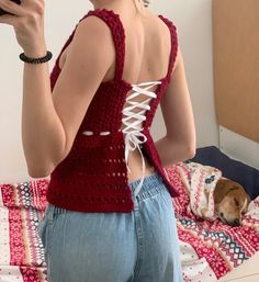 a woman taking a selfie with her cell phone while standing in front of a bed