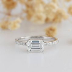 a white gold ring with an emerald cut diamond