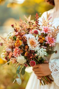 a woman holding a bouquet of flowers in her hands